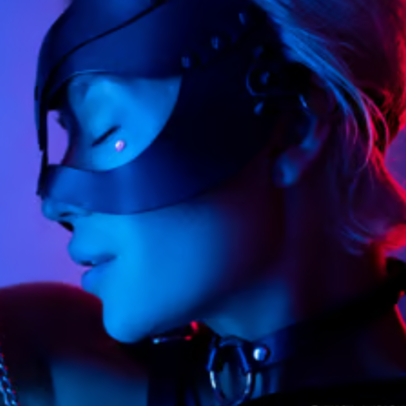 Close-up neon-lit portrait of masked person in blue and red lighting with futuristic aesthetic